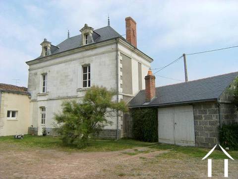 Maison et garage annexé à la maison, qui renferme également la chaudière du système de chauffage central et le réservoir de mazout  