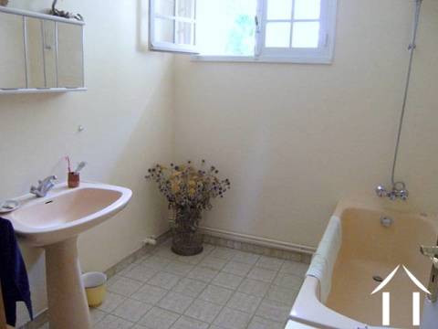 Salle de bains au rez-de-chaussée avec baignoire et lavabo. Il y a un WC séparé  