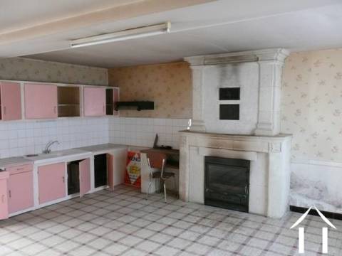 La cuisine avec son poële à bois avec insert et sa cheminée.   