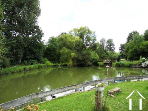 Vue de la terrasse. Le lac est alimenté par une source d'eau naturelle qui monte derrière la propriété et forme un petit ruisseau qui avait l'habitude de faire tourner la roue (plus en position).      