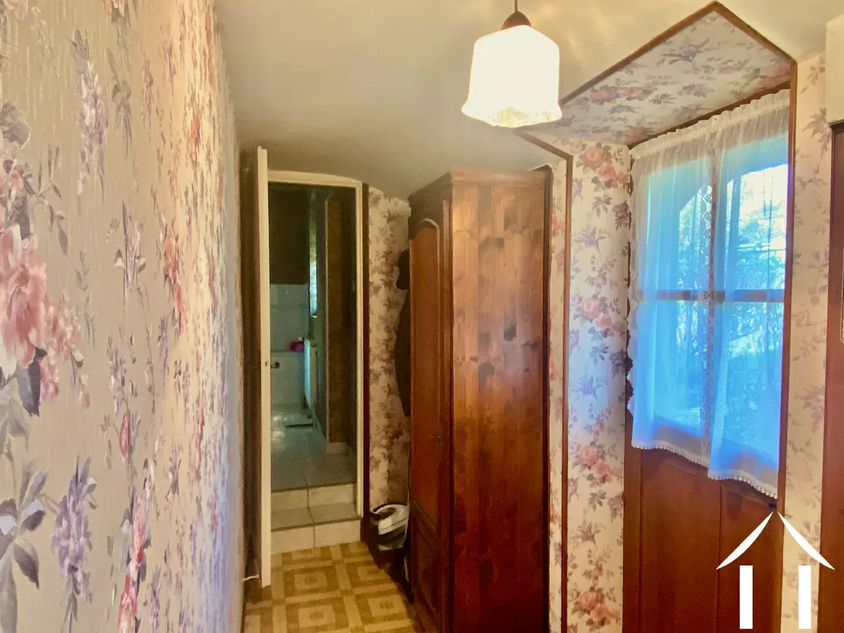 Couloir au rez-de-chaussée, à droite la porte vers le jardin, au fond, la salle de bains