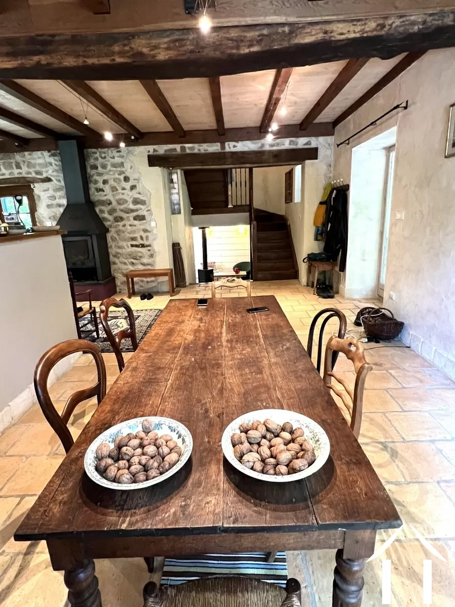 La salle à manger. A dr. la porte vers la véranda, au fond et en contrebas, le salon.