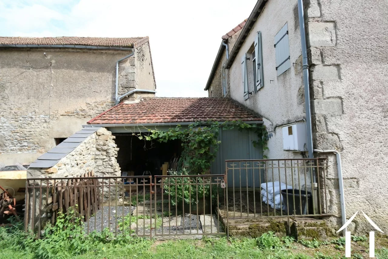 Arrière de la maison avec accès à l'abri et l'atelier qui mène à la buanderie