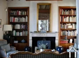 woonkamer met vaste boekenkasten en houtkachel