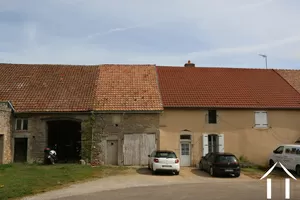 Grange avec porte de garage blanche et tuiles orange claire