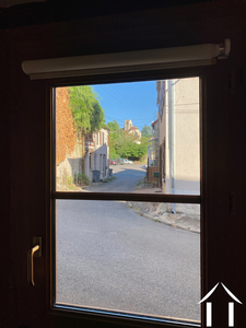 La rue de la Tannerie vue à travers la porte d'entrée vitrée. A l'arrièreplan, l'église Saint-Martin du XIIème siècle