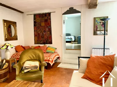 Le salon avec un lit d'appoint et la porte vers la chambre