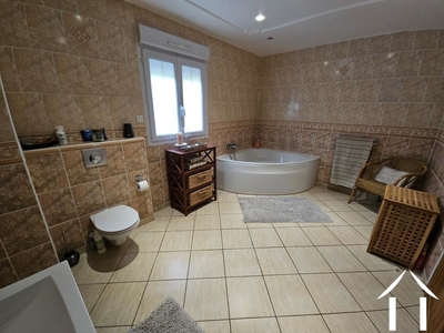 Salle de bain avec baignoire d'angle, douche, lavabo et toilettes
